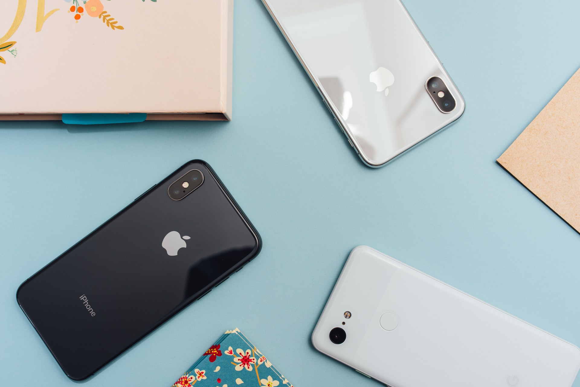 Des iPhone posés sur un bureau, aux côtés d'un Pixel 3