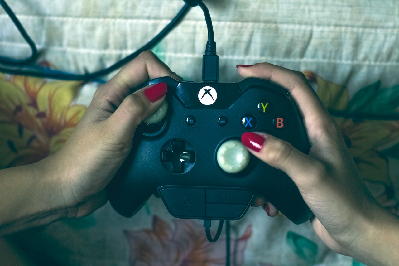 Une photo montrant une femme en train de tenir le contrôleur d'une Xbox One