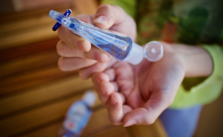 Les mains d'une femme qui utilise du gel hydroalcoolique