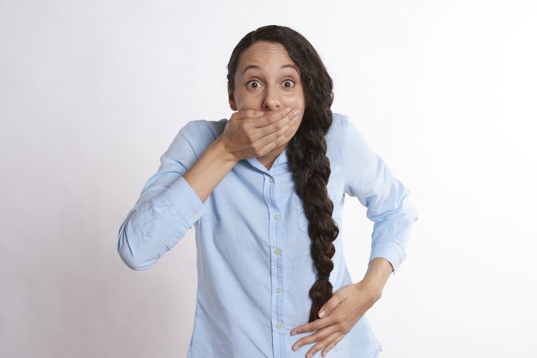 Une jeune femme riant en se cachant la bouche