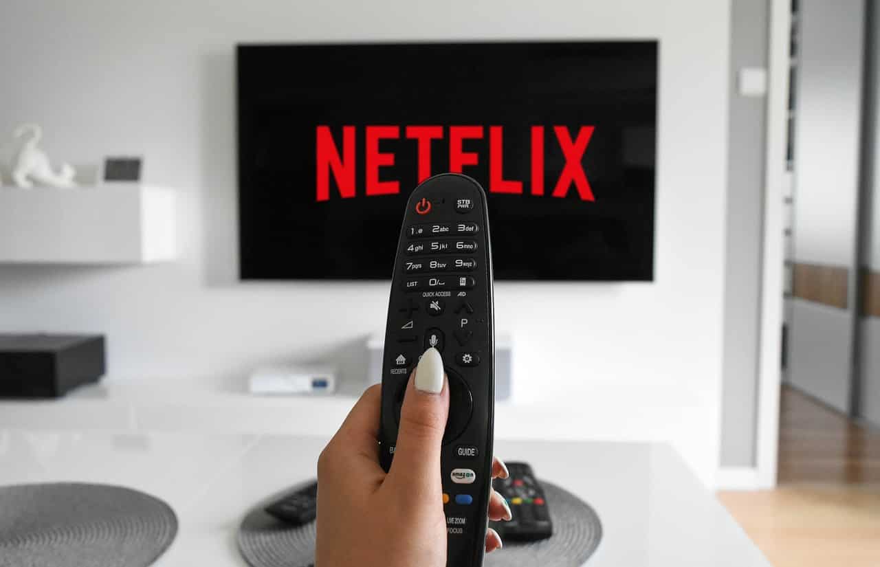 Netflix sur une télévision et une télécommande en main