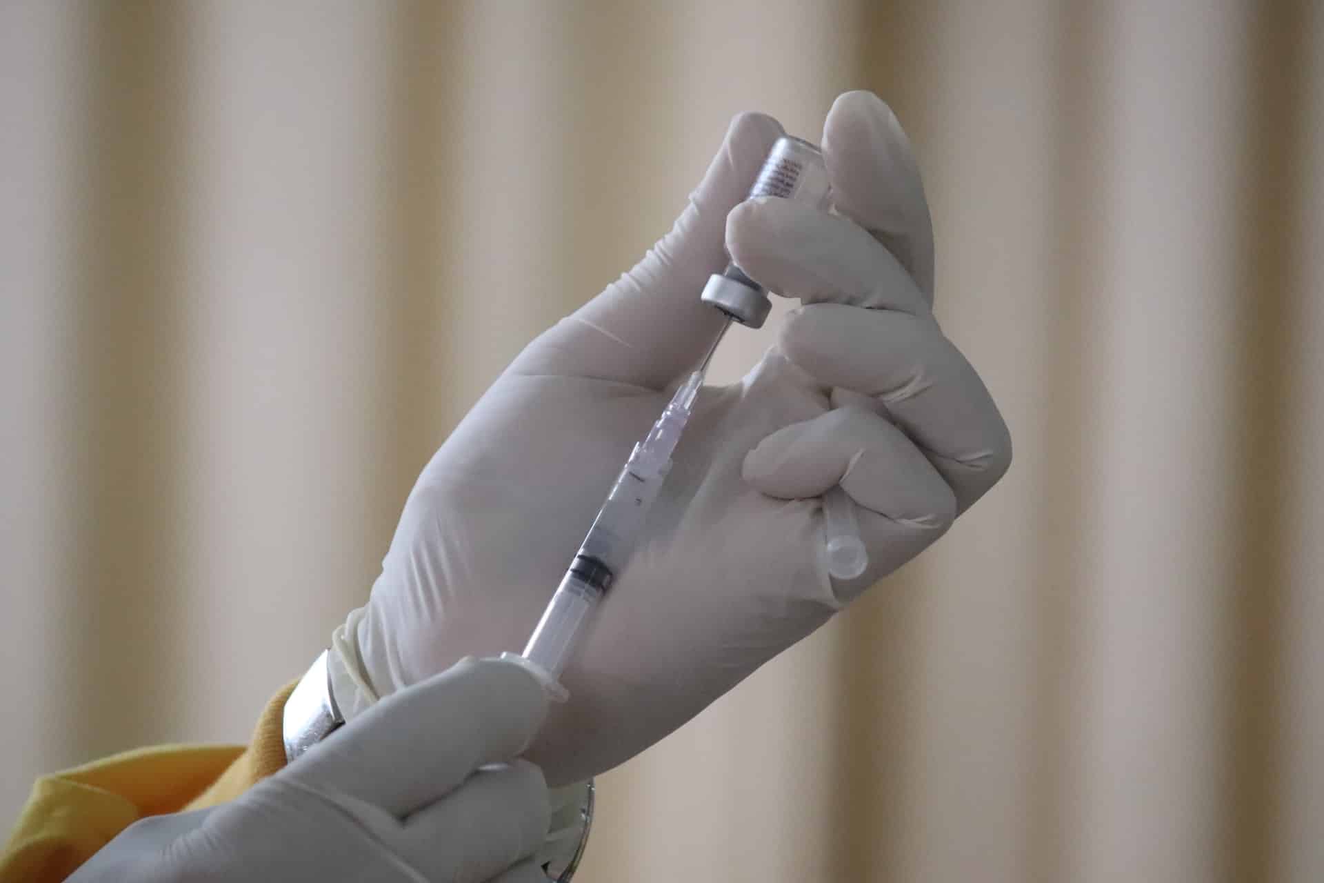 Une personne en train de préparer une injection de vaccin contre la Covid-19