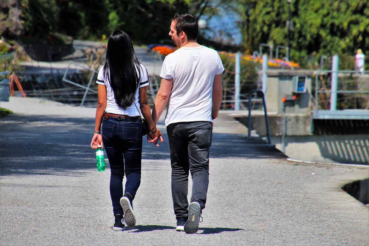 Un couple en train de marcher en se tenant la main