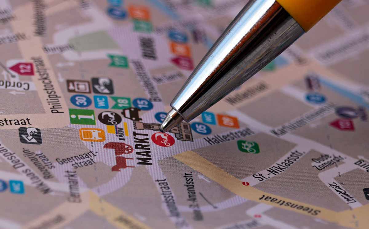 Une photo montrant un stylo indiquant un endroit sur une carte