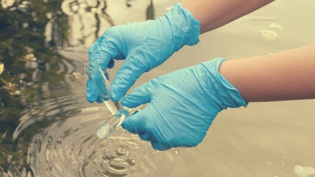 Un scientifique qui prélève un échantillon d'eau