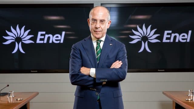 Francesco Starace, le PDG d'Enel se tient debout devant des logos de son entreprise.
