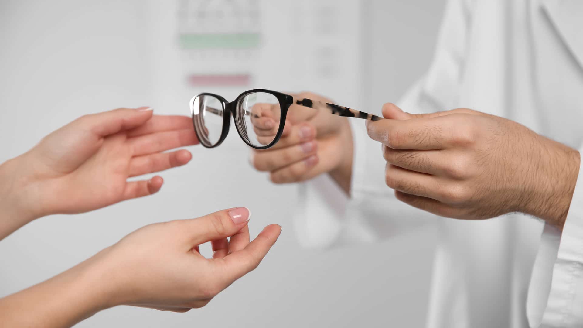 Un ophtalmologue qui donne une paire de lunette à une personne