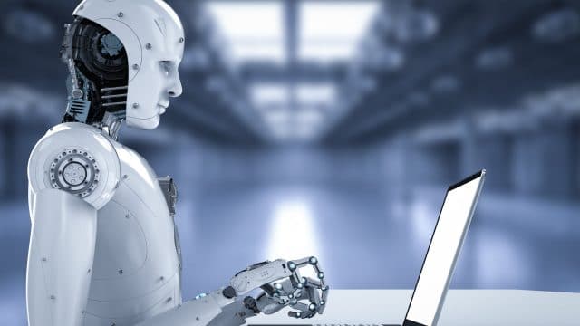 Un robot en train de manipuler un ordinateur