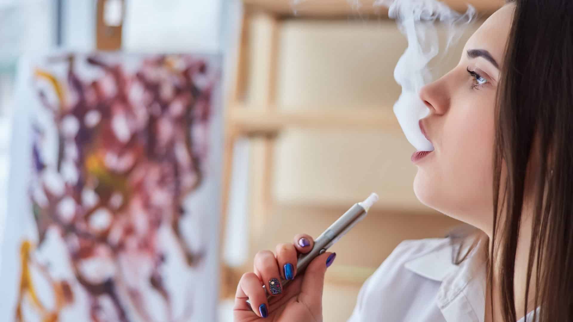 Une jeune fille fumant une cigarette électronique.