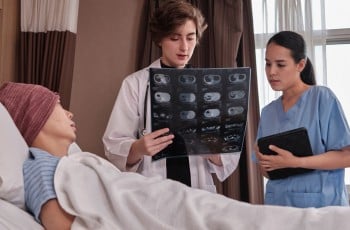 Un médecin en blouse blanche analyse l'examen radiographique d'un patient atteint de cancer.