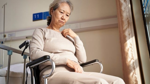 Une femme âgée atteint d'Alzheimer déprime sur un fauteuil roulant.