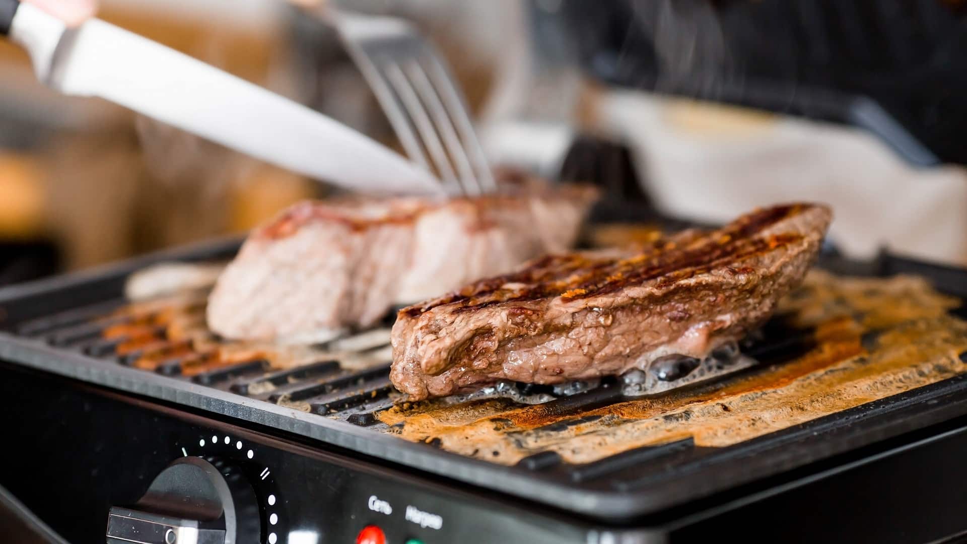 Gros plan sur un délicieux steak de bœuf sur un gril électrique.