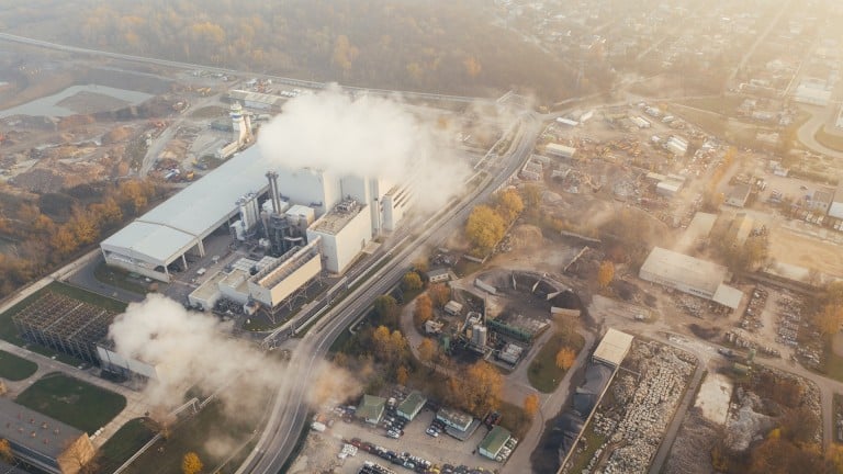 Une usine libérant de grosses quantités de gaz à effet de serre vue du ciel.